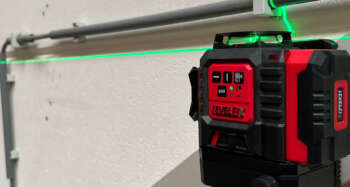 De LevelFix CCL283G multilijnlaser bevestigd aan een metalen stelling met de meegeleverde magnetische wandklem.