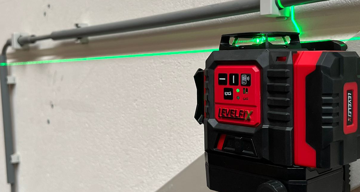 De LevelFix CCL283G multilijnlaser bevestigd aan een metalen stelling met de meegeleverde magnetische wandklem.