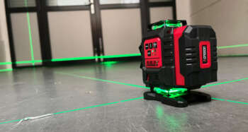 LevelFix CCL284G 4D lijnlaser in actie op de vloer met alle vier de groene 360-graden laserlijnen.