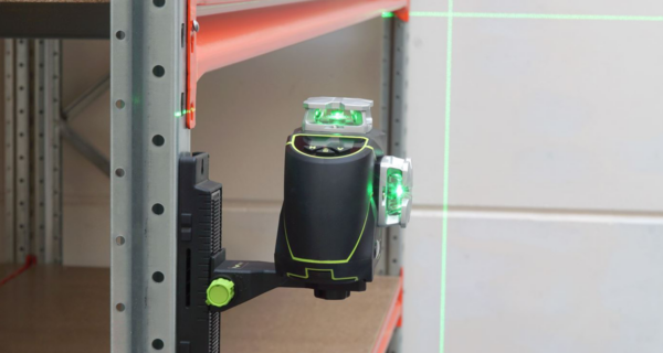 Een tegelzetter gebruikt de groene horizontale laserlijn van de Birdy CL360-3G voor het uitlijnen van wandtegels in een badkamer.
