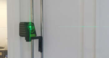 Een tegelzetter gebruikt de verticale lijn van de Birdy X2G als referentie voor het plaatsen van wandtegels.