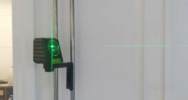 Een tegelzetter gebruikt de verticale lijn van de Birdy X2G als referentie voor het plaatsen van wandtegels.