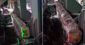 Zijaanzicht van een Delta VX-laser die een rode lijn projecteert voor nauwkeurige positionering op een industriële zaagmachine.