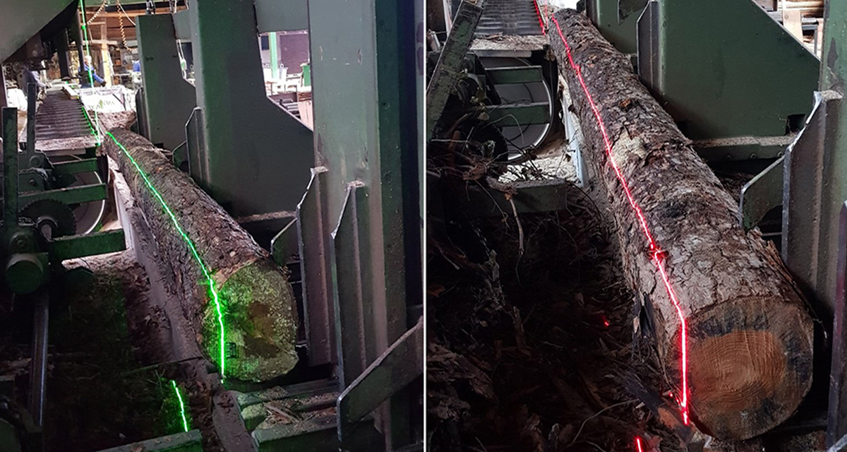 Zijaanzicht van een Delta VX-laser die een rode lijn projecteert voor nauwkeurige positionering op een industriële zaagmachine.