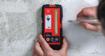 A close-up of the Leica RGR300-D digital receiver for line lasers being utilized in a precise leveling task.