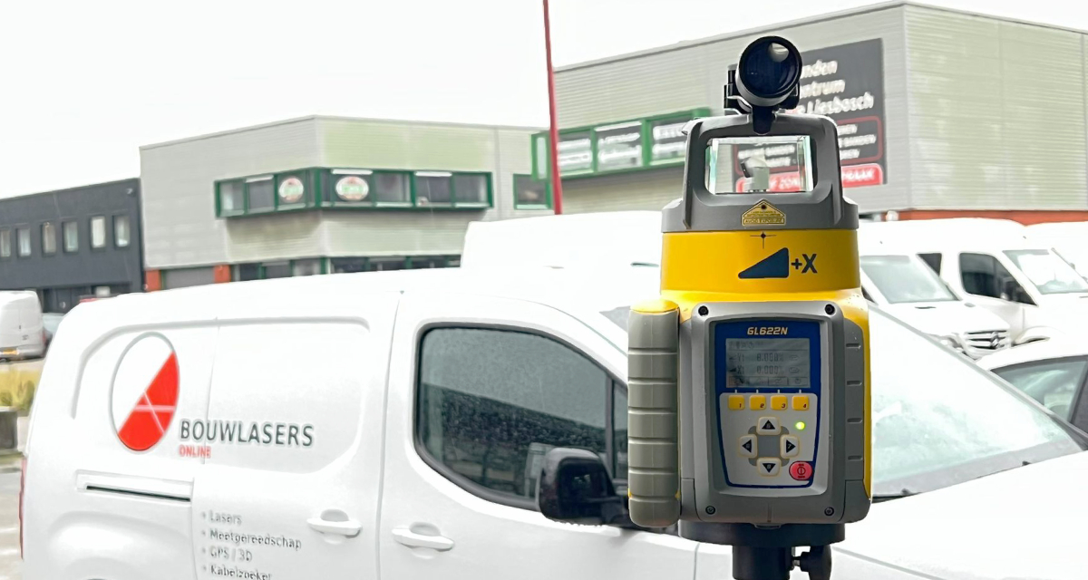 Scope gemonteerd op een gele Spectra GL412N afschotlaser op een statief, in gebruik op een bouwplaats.